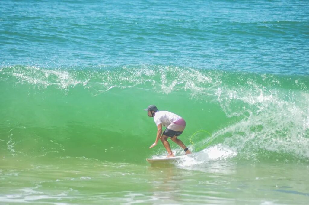 O deputado Lucas Scaramussa surfa uma onda na praia de Regência, em Linhares